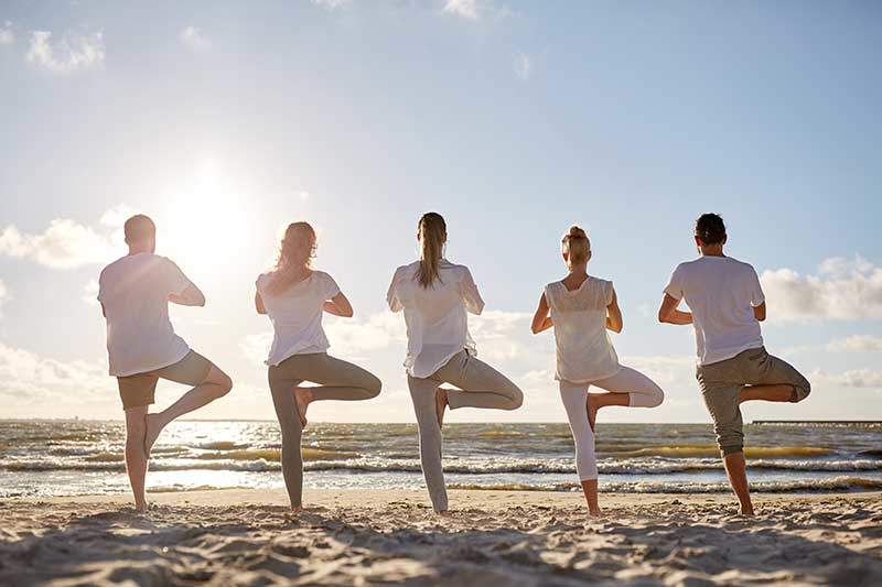 yoga-fasten-mallorca-buchinger-gesundblick Menschen beim auf Yoga am Strand